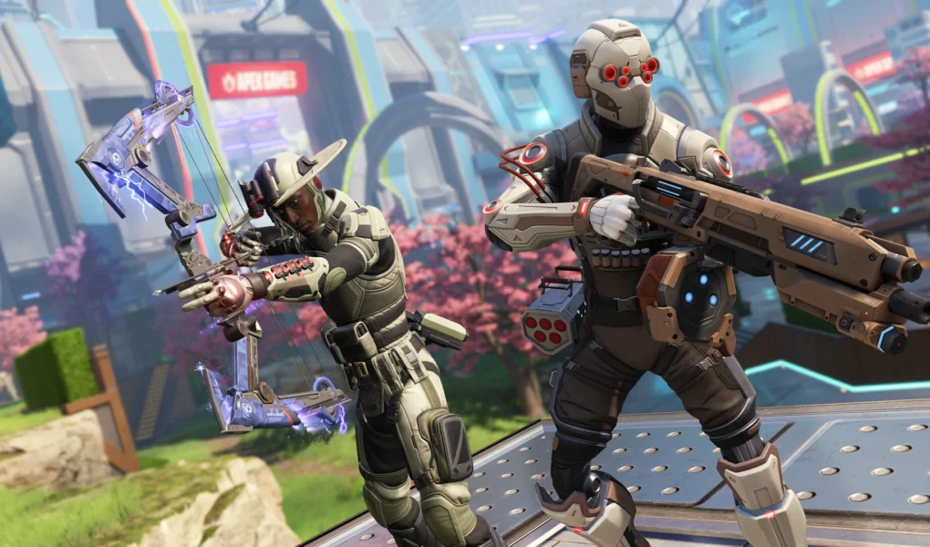 Dois personagens de Apex Legends equipados com trajes táticos e armas tecnológicas em um cenário futurista com cerejeiras ao fundo. Um personagem à esquerda empunha um arco eletrificado e o à direita segura um rifle de assalto pesado